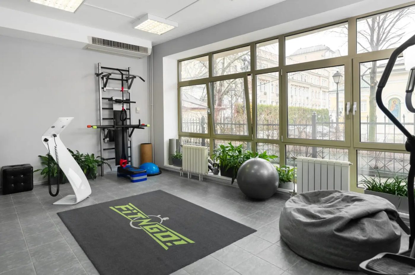 Зал студии FIT-N-GO: окна, коврик, фитболы